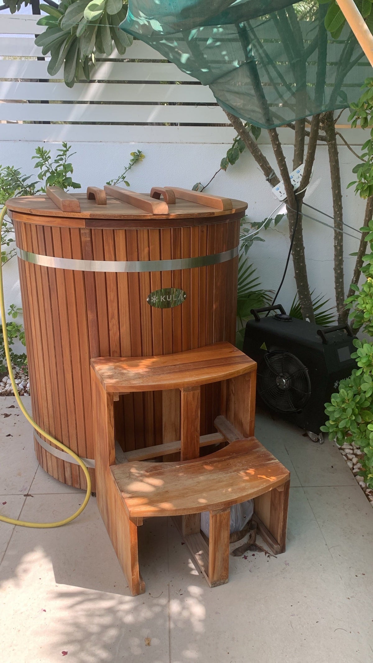 KULA Shogun red cedar barrel ice bath with lid, steps and chiller in a Dubai villa garden