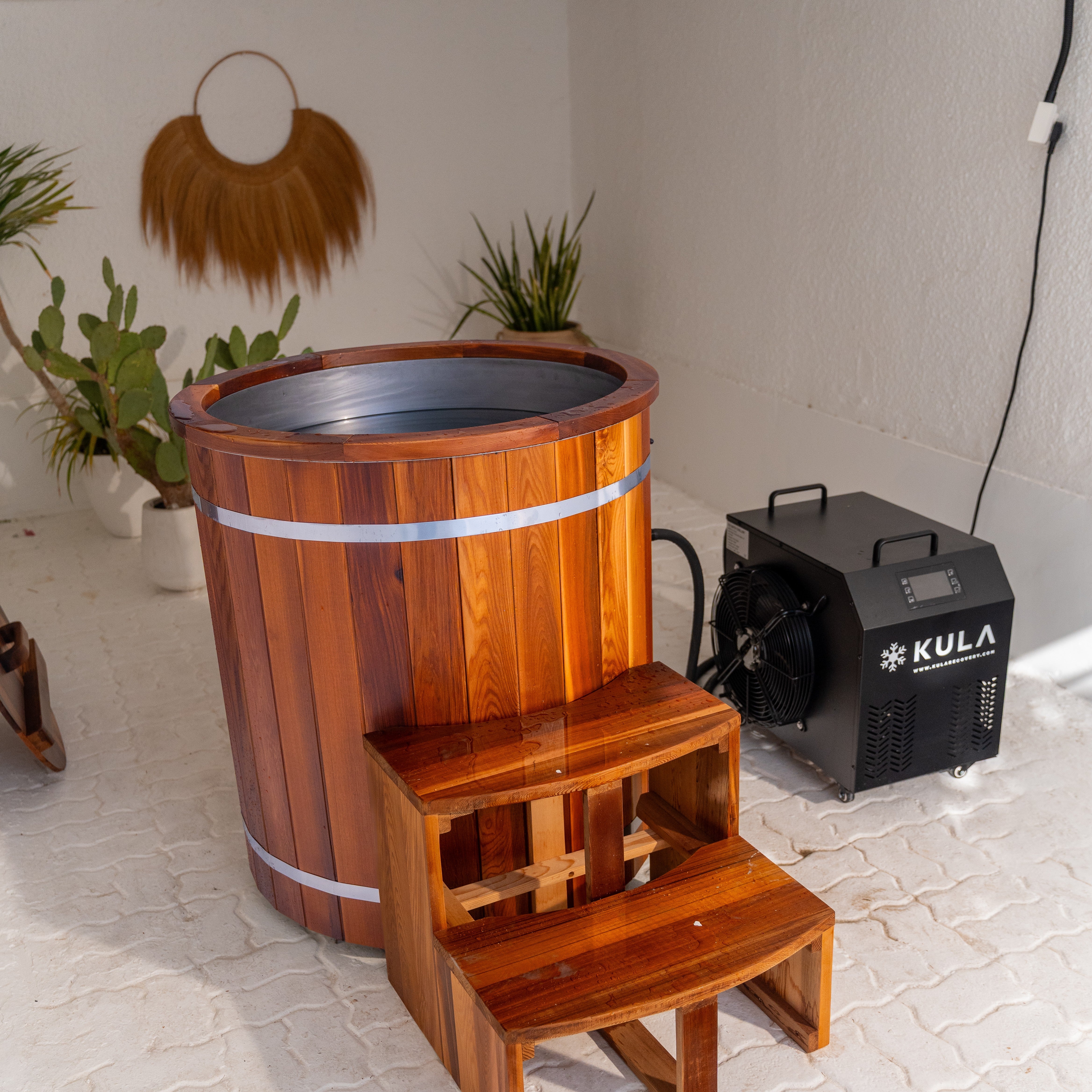 Woman relaxing in KULA Shogun red cedar barrel ice bath at home